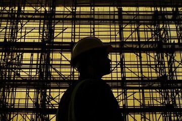 Canvas Print - Silhouette of a Construction Worker in Front of a Scaffolding Window