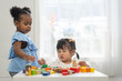 © Art_Photo - Two diverse children playing with colorful wooden blocks early childhood education, learning and development fun activities for kids in preschool, creative playtime, cognitive growth, friendship