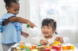 © Art_Photo - Two diverse children playing with colorful wooden blocks early childhood education, learning and development fun activities for kids in preschool, creative playtime, cognitive growth, friendship