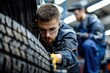 © Vii - A person working on a car tire in a well-lit garage, giving advice for automotive uses