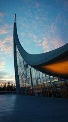 Canvas Print - Modern church with a unique curved design against a pink and blue sunset sky.