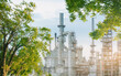 © noppadon - Oil refinery plant from industry zone with tree and blue sky, large Oil and gas petrochemical industrial, Refinery factory oil storage tank and pipeline steel, Ecosystem and good environment.