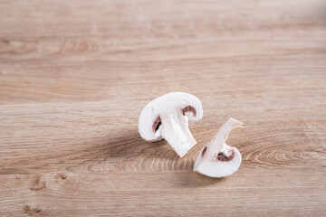 White champignons cut on wooden table in kitchen