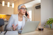 © Dragana Gordic - Senior Businesswoman Talking on Phone While Working on Laptop
