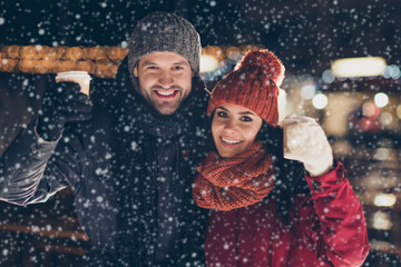 Wall Mural - Merry christmas Photo of two people pair with hot beverage in hands celebrating x-mas evening raising mugs telling toasts wearing warm coats outside