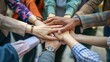 © Surachetsh - Business professionals place their hands together in a show of unity and collaboration, shared commitment to success in a corporate environment.
