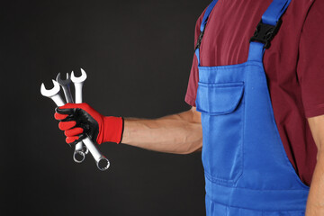 Wall Mural - Auto mechanic with wrenches on black background, closeup