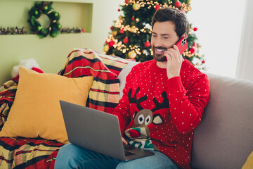 Canvas Print - Photo of nice young man speak phone use laptop ugly sweater christmas atmosphere apartment indoors