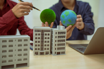 Two businessmen work at desks in an office,discussing city clean energy strategies global technology trends to support efficient energy use.Seoul's 2050 carbon neutrality plan focuses on buildings