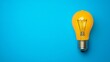 © Oatkhaphon - A vibrant yellow light bulb on a bright blue background, symbolizing ideas, creativity, and innovation.