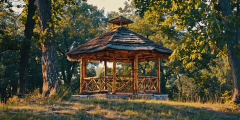 Wall Mural - Wooden gazebo with thatched roof perched on a hill in the park