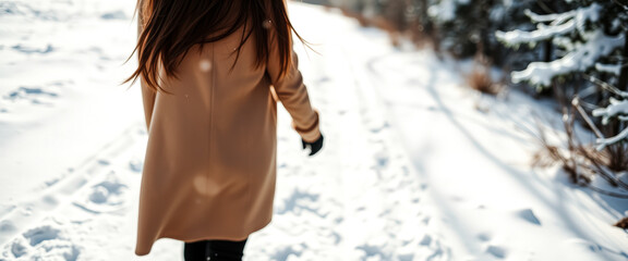 Canvas Print - Woman in brown coat walking in the snow