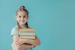 © Alexandr - Smiling young female student with a stack of books, conveying themes of education, learning, and academic success.