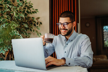 Young caucasian businessman working from home on laptop