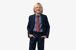© somemeans - Blond grimacing boy in a blue suit and a red tie. Isolated on white background.