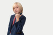 © somemeans - Portrait of young businessman with blond hair, dressed in blue suit and red tie, points a finger to the side isolated on white background.