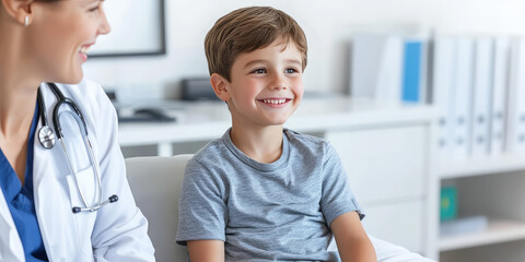 A smiling child boy sitting in a white medical office on a couch for an examination.