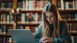 © Yuwarin - A student is using a laptop in the library