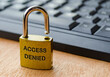 © JeromeMaurice - Access Denied text engraved on padlock with keyboard background. Password and use access concept