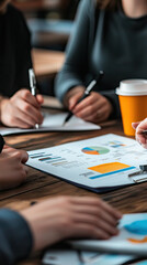 Poster - Collaborative colleagues discussing marketing strategy, analyzing charts and graphs on table. atmosphere is focused and productive, with coffee cups nearby