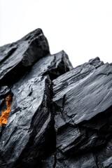 Close-up of dark, textured rock formation with orange streaks, showcasing nature's raw beauty and geological diversity.