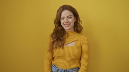 Wall Mural - Young caucasian woman wearing sweater standing looking positive and happy standing and smiling with a confident smile showing teeth over isolated yellow background