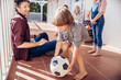 © Marko Geber - Family playing with soccer ball on patio together