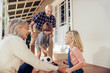 © Marko Geber - Grandparents playing soccer with grandchildren on patio