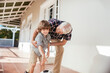 © Marko Geber - Grandfather playing soccer with grandson on patio