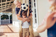 © Marko Geber - Grandfather playing soccer with grandson on patio