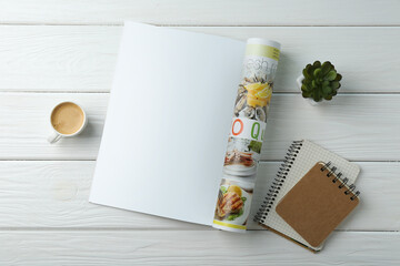 Wall Mural - Open magazine with blank page, coffee, plant and notebooks on white wooden table, flat lay. Mockup for design