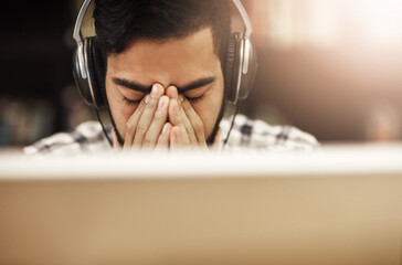 Canvas Print - Computer, headphones and Indian man in library with stress, headache and education at university. Anxiety, study and tired college student on campus with online course, class or webinar in earphones