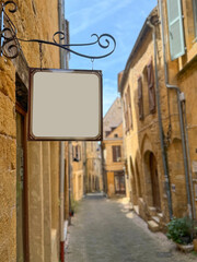 blank sign board hanged on building entrance at narrow street