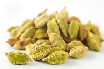 Canvas Print - A pile of cardamom seeds on a white surface, ideal for use in recipes or as a decorative element