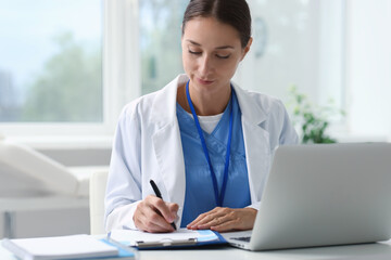 Canvas Print - Nurse taking notes at table in clinic