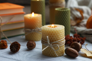 Wall Mural - Burning candles and autumn decor on grey wooden table, closeup