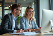 © Pixel Focus AI - Two busy happy professional business man and woman executive leaders team using laptop working on computer at work desk having conversation on financial project at meeting in office