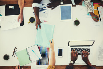 Poster - Above, hands or designers in meeting for documents, teamwork and brainstorming in startup. Giving, color choice and strategy with laptop, people or graphs with paperwork, budget report or feedback