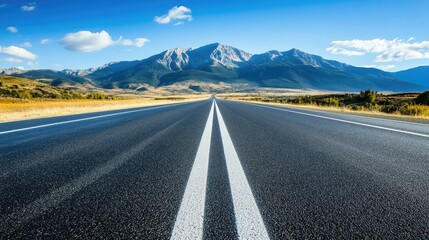 Poster - Horizontal lines of freshly painted road markings on an empty highway, with a scenic mountainous backdrop