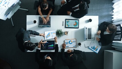 Wall Mural - Top down aerial view of professional boss invites project manager to explain about marketing plan at white board while giving a handshake. Group of diverse investor listen presentation. Directorate.