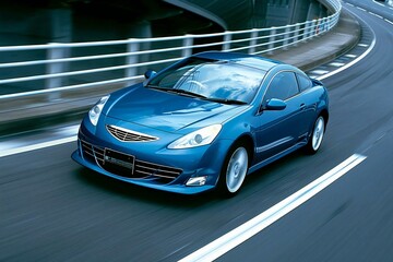 sleek blue business car speeding around a highway curve.