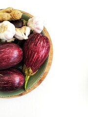 Raw vegetables on a plate. There is negative space and a white background