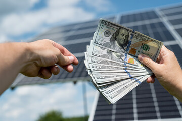 Poster - Business man handing over dollar money to another hand against solar panel