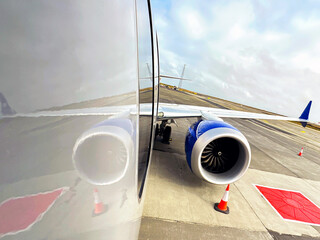 Aircraft engine and wing of a passenger jet reflected in the plane's fuselage. No people. Travel concept.