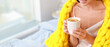 © Pixel-Shot - Morning of young woman with warm plaid drinking tea in bed