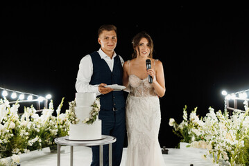 newlyweds happily cut and taste the wedding cake