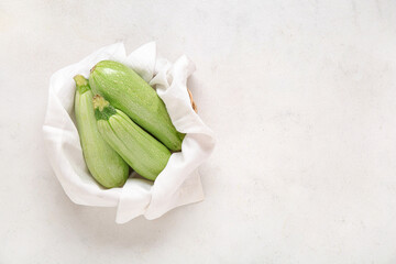 Wall Mural - Bowl with fresh green zucchini on light background