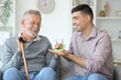 © Pixel-Shot - Senior man with his son taking pills at home