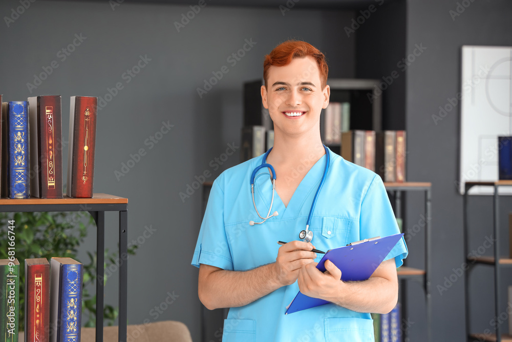 Male medical student with clipboard in library