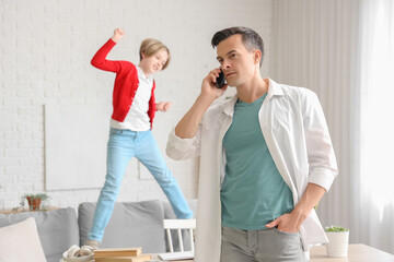 Poster - Young man with mobile phone stressed of his noisy little son at home